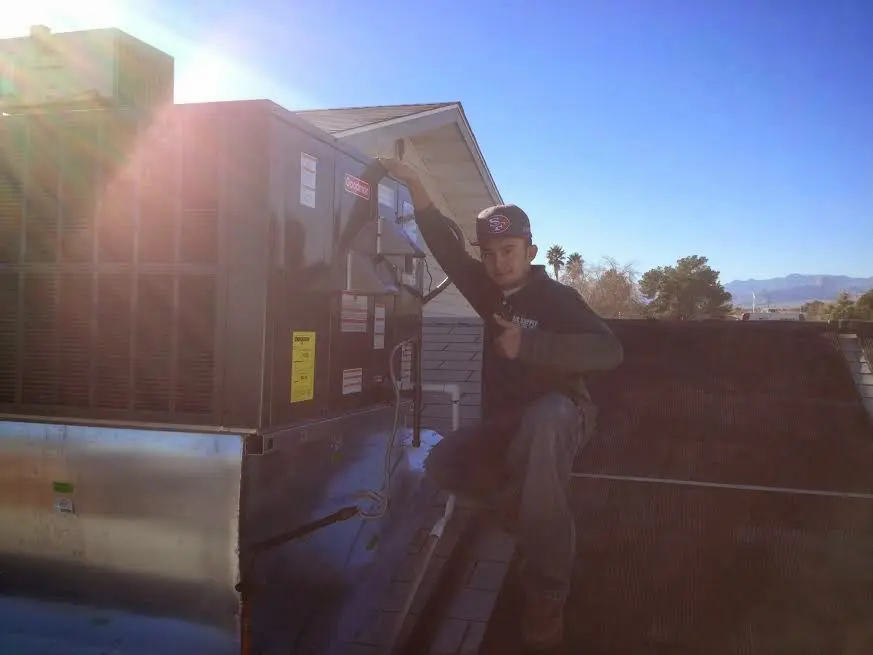 HVAC technician performing Heat Pump Repair on a rooftop unit in Palm Valley
